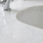 A white cultured marble bathroom vanity top with an integrated sink and chrome faucet