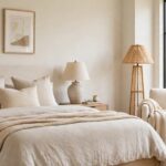 Bright master suite bedroom with a large bed, bedside tables and a reading corner by the window