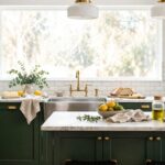 Deep hunter green kitchen cabinets with brass hardware and white walls