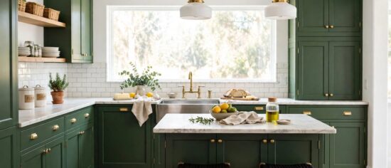 Deep hunter green kitchen cabinets with brass hardware and white walls