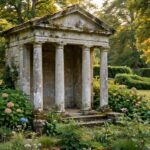 A stone garden folly in the shape of a small temple standing among trees in a landscaped garden